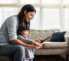 Una mujer y un niño mirando un teléfono móvil.