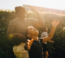 Una mujer y un niño ríen fuera.