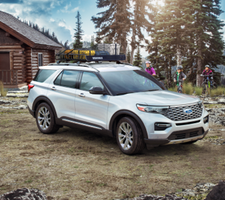 Un explorador blanco aparca en un camping junto a tres personas en bicicleta.